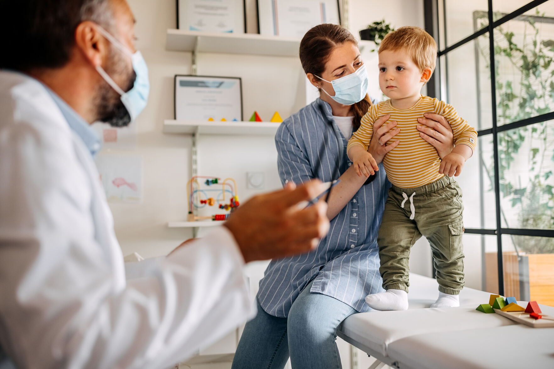 Baby boy with mother visiting doctor for vaccine